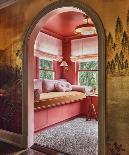 pink reading room with daybed seen through an arched doorway