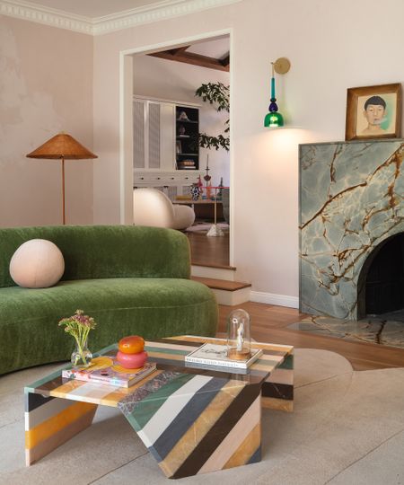 living room with green sofa and striped coffee table
