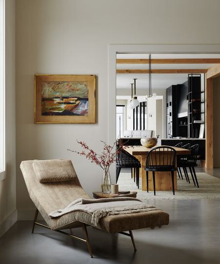 chaise lounge in a the corner of a living room, looking through a door to the kitchen diner behind