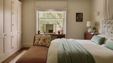neutral london bedroom designed by Emma Ainscough with a wall of wardrobes and a canopy bed