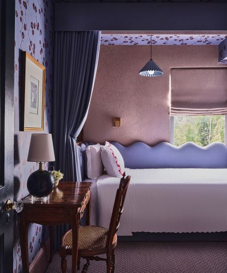 purple bedroom with canopy above the bed and curtain hanging down 