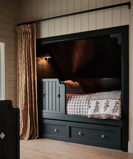 Bedroom with shiplap walls, built-in bed nook painted in dark blue, and gingham bedding and blockprint throw 