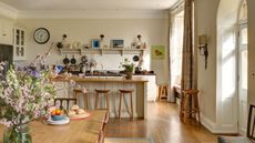 An open planned country kitchen diner wooden floors, counters and open shelving