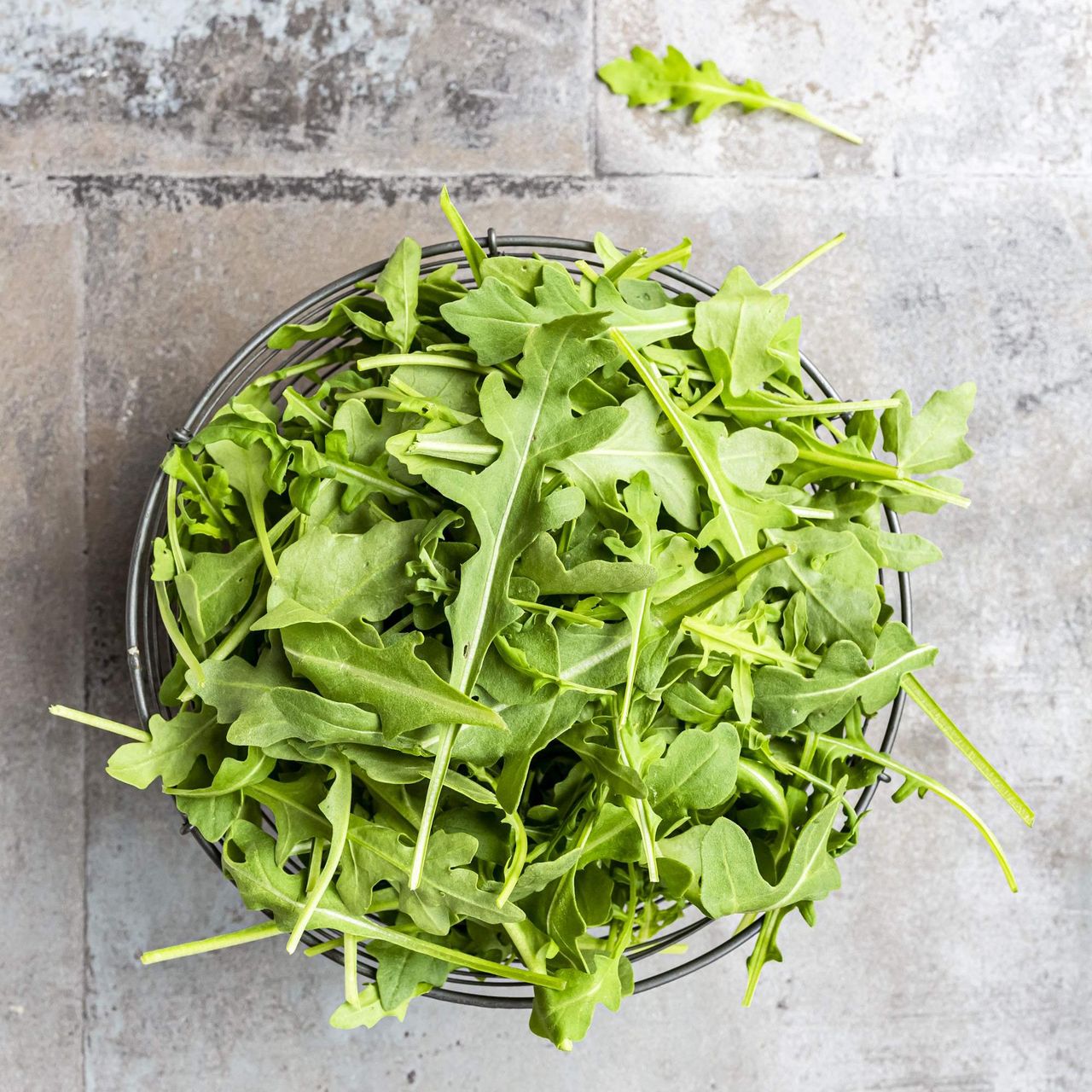 Freshly-harvested arugula leaves in a basket